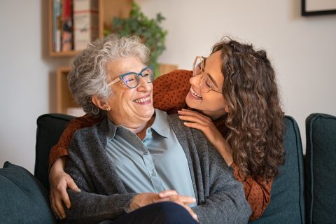 A woman and a young woman hugging.